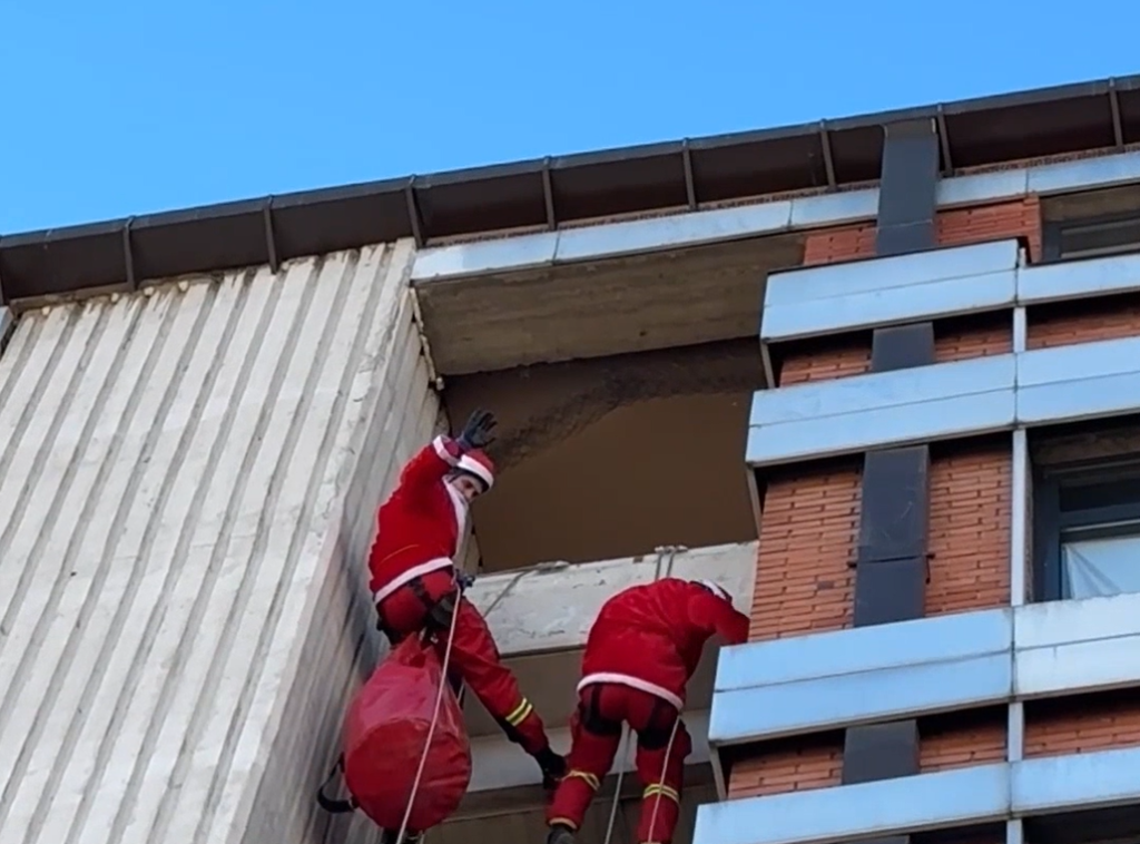 Deda Mrazevi sa krova piroteske bolnice delili paketiće deci